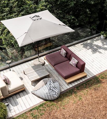 area arredata con salotto da estermo, una terrazza panoramica elegante, pavimento in legno modernocon vetro come balaustra grande albero al lato