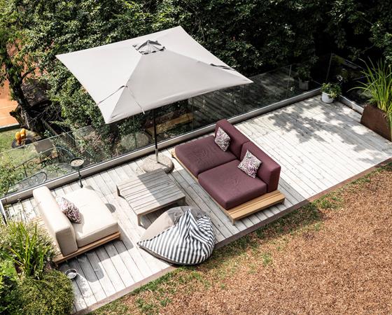 area arredata con salotto da estermo, una terrazza panoramica elegante, pavimento in legno modernocon vetro come balaustra grande albero al lato