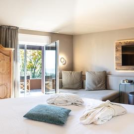 junior suite  Hotel Panorama a Fai della Paganella con balcone panoramico, arredi in legno e atmosfera alpina elegante.