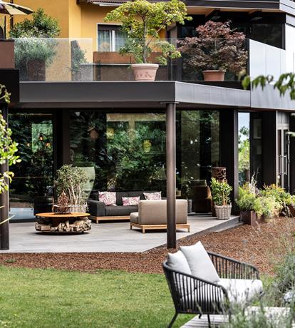 Spazi eleganti immersi nel verde allo Sport Hotel Panorama di Fai della Paganella. Ampie vetrate, terrazze con parapetti in vetro e arredi outdoor di design