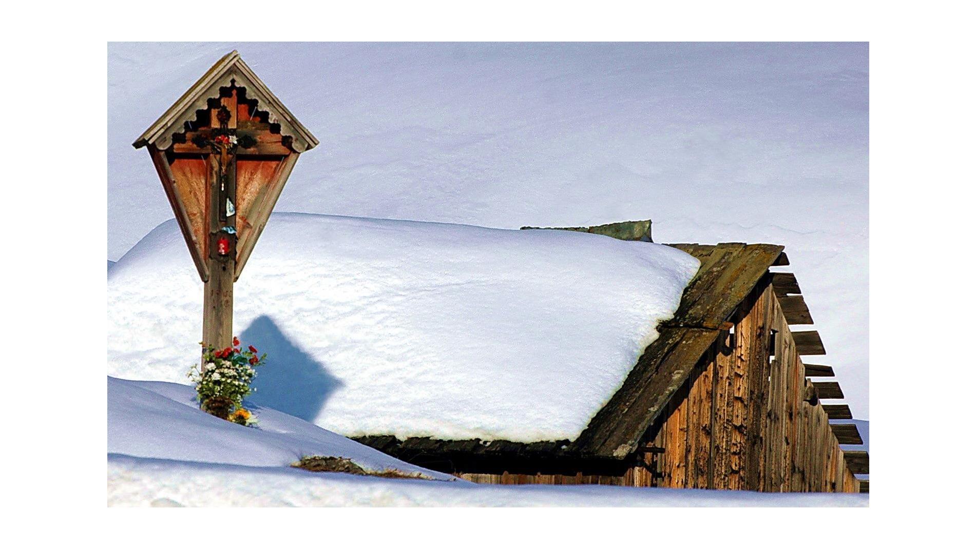 immagine di neve con tetto di baita ricoperto di neve