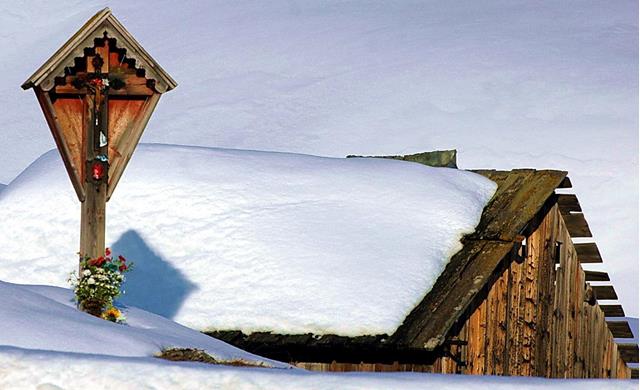 immagine di neve con tetto di baita ricoperto di neve