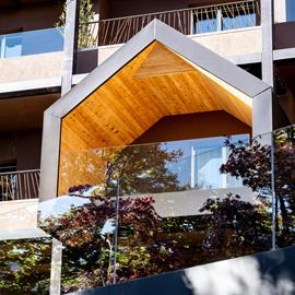 Balconi dal design contemporaneo, con linee geometriche e legno a vista che dialogano con la natura circostante.