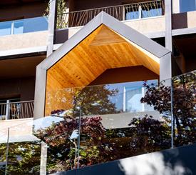 Balconi dal design contemporaneo, con linee geometriche e legno a vista che dialogano con la natura circostante.