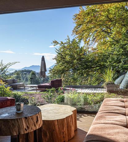 Elegante salotto con ampie vetrate affacciate sul giardino e sulle Dolomiti del Brenta allo Sport Hotel Panorama di Fai della Paganella.