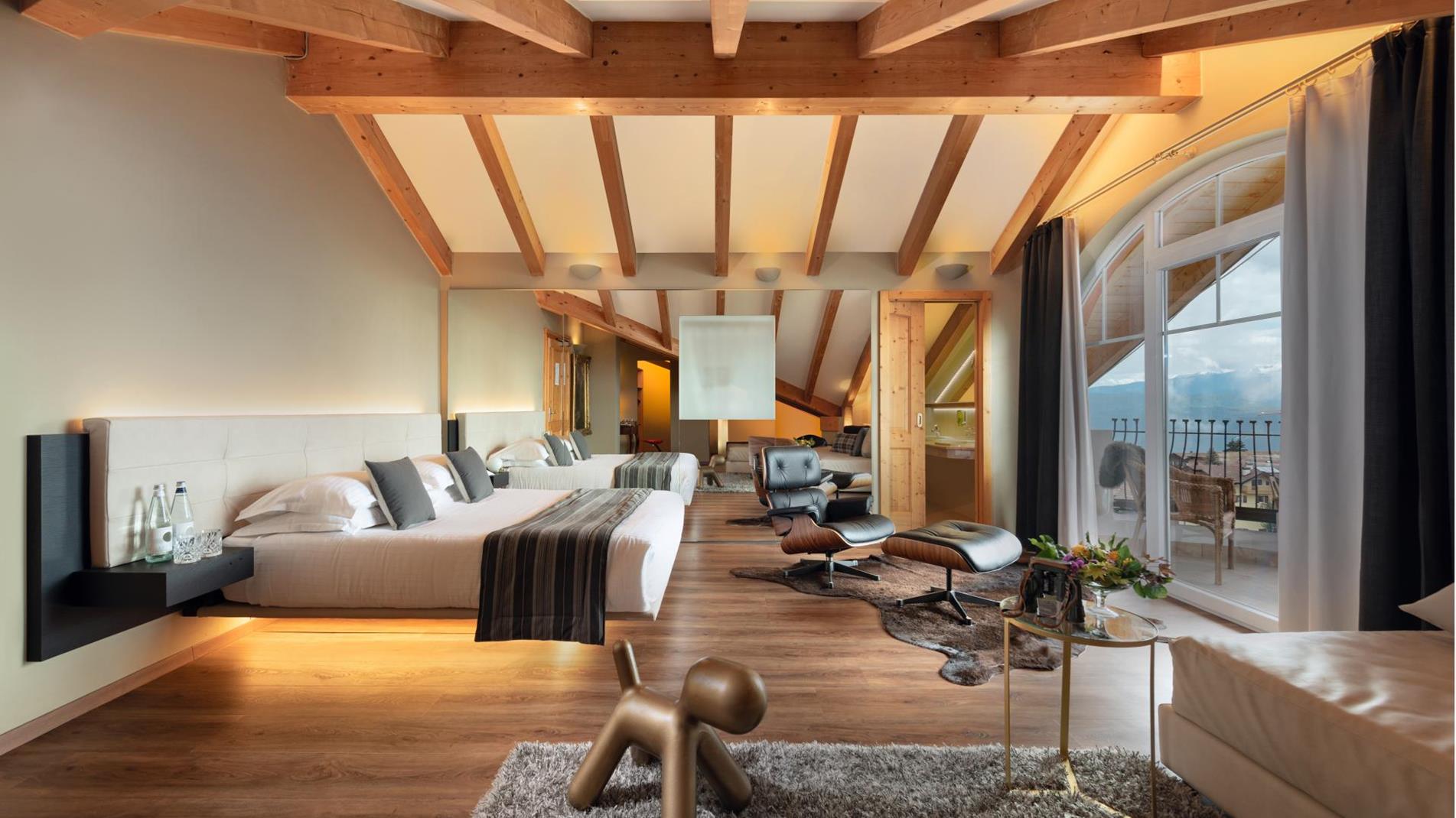 caratterizzata da ampie vetrate e balcone panoramico affacciato sulle Dolomiti del Brenta. Ambienti luminosi, arredi di design e zona relax dedicata creano un’atmosfera elegante e accogliente, ideale per soggiorni romantic