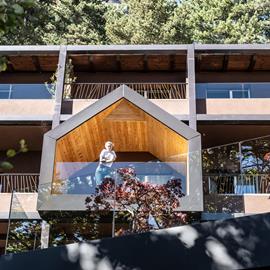 Architettura contemporanea immersa nel verde, con balconi panoramici che si aprono sul paesaggio di Fai della Paganella.