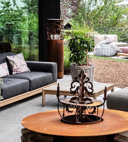 Raffinata area lounge indoor-outdoor allo Sport Hotel Panorama di Fai della Paganella, dove ampie vetrate collegano gli spazi interni al giardino. Comodi divani, dettagli in legno e arredi contemporanei