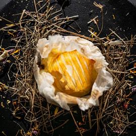 piatto nero gourmet con fieno e pietanze montane