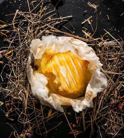 piatto nero gourmet con fieno e pietanze montane