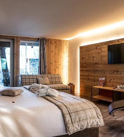 Junior suite in Paganella, con arredi in legno e atmosfera calda in stile alpino.