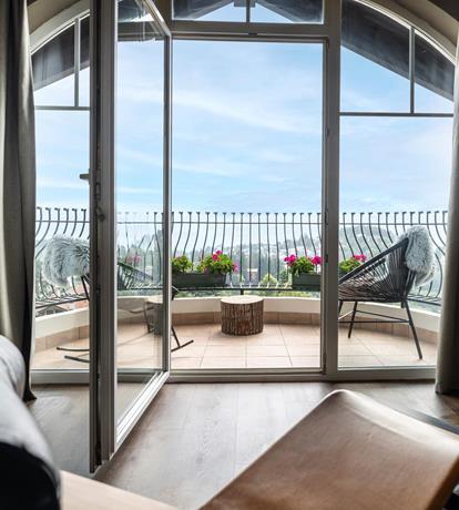 suite moderna con grandi vetrate e terrazza panoramica con vista sulle montagne e particolare design dormuse Le Corbusier