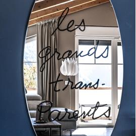 Specchio di design con calligrafia artistica “Les Grandes Heures Parenthèses”, pezzo iconico che caratterizza l’ambiente con stile contemporaneo. dettaglio.