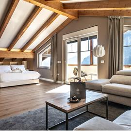Travi in legno, luce naturale e vista sulle Dolomiti: una suite spaziosa dove vivere il tuo soggiorno in totale comfort.