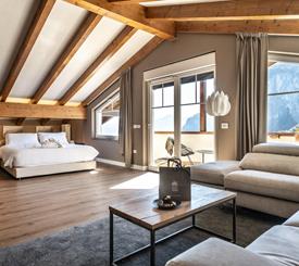 Travi in legno, luce naturale e vista sulle Dolomiti: una suite spaziosa dove vivere il tuo soggiorno in totale comfort.