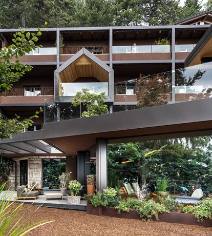 Architettura contemporanea immersa nella natura allo Sport Hotel Panorama di Fai della Paganella. Linee moderne, balconi panoramici in vetro